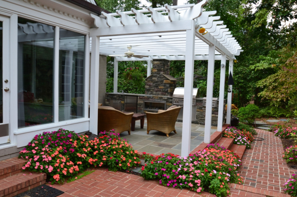 Modelo de terraza tradicional renovada de tamaño medio en patio trasero con cocina exterior, suelo de hormigón estampado y pérgola