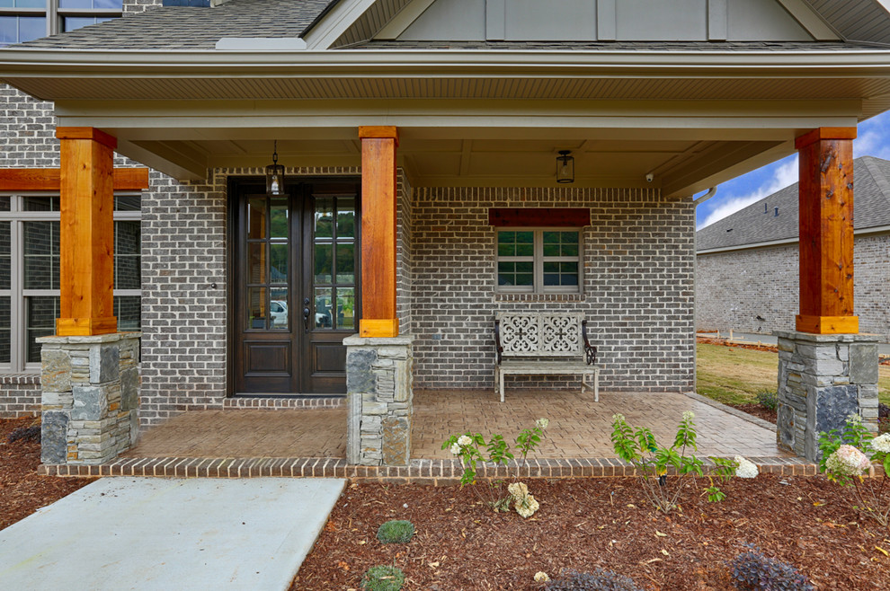 Mid-sized arts and crafts stamped concrete front porch photo in Other with a roof extension
