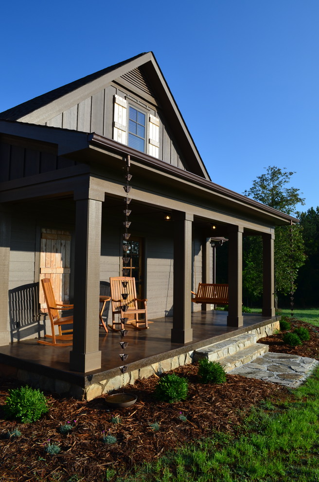 This is an example of a large classic veranda in Charlotte with a roof extension, concrete slabs and feature lighting.