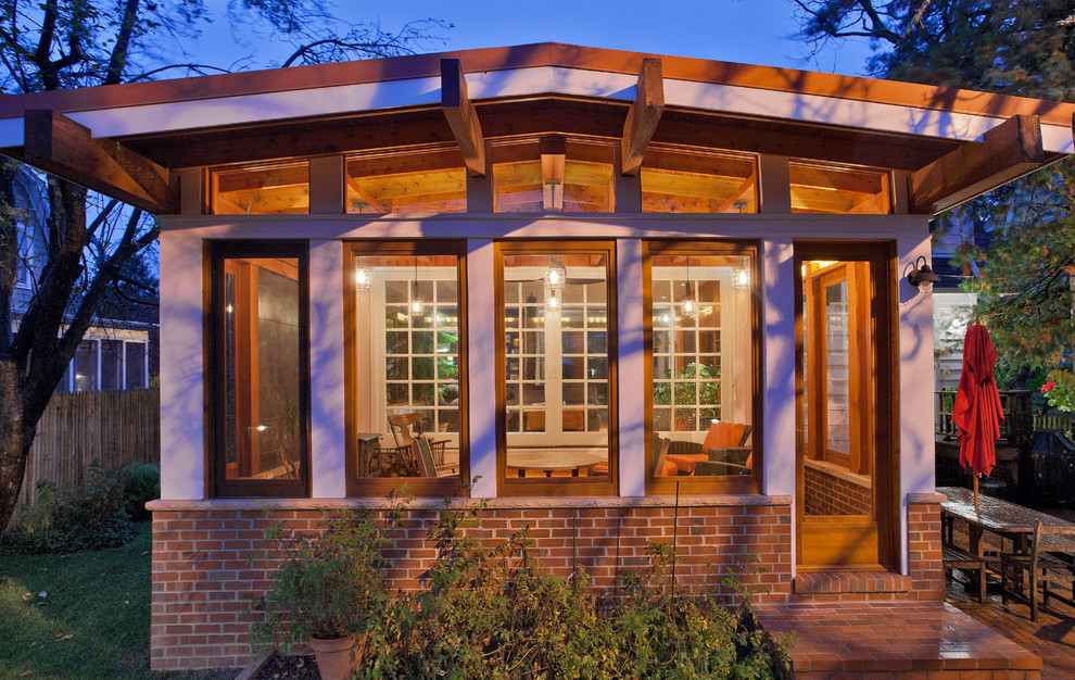 Esempio di un portico american style dietro casa con pavimentazioni in mattoni e un tetto a sbalzo