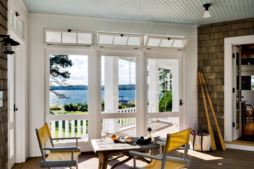 Réalisation d'un porche d'entrée de maison marin avec une terrasse en bois, une extension de toiture et une moustiquaire.