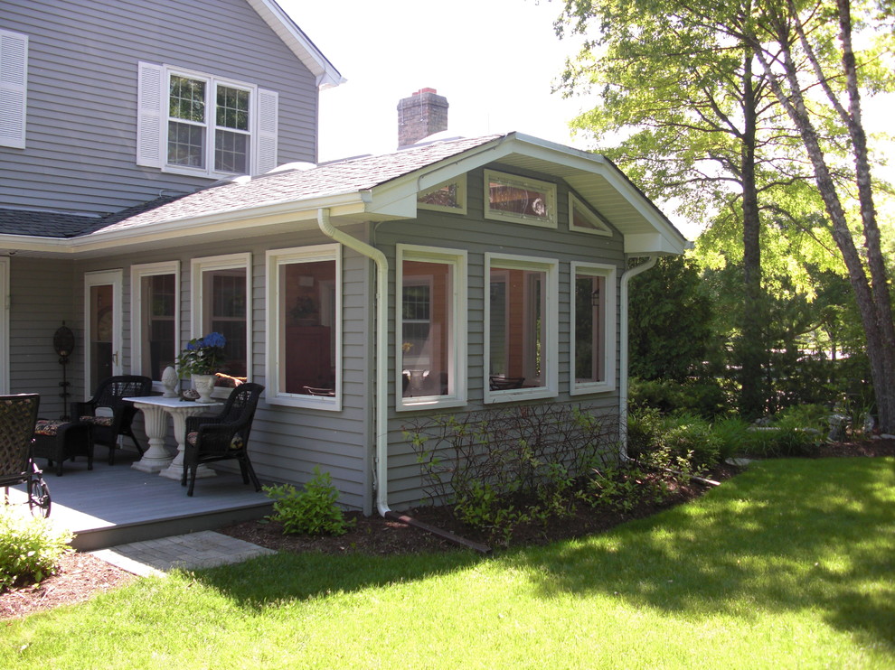Klassisk inredning av en mellanstor veranda på baksidan av huset, med utekrukor, betongplatta och takförlängning