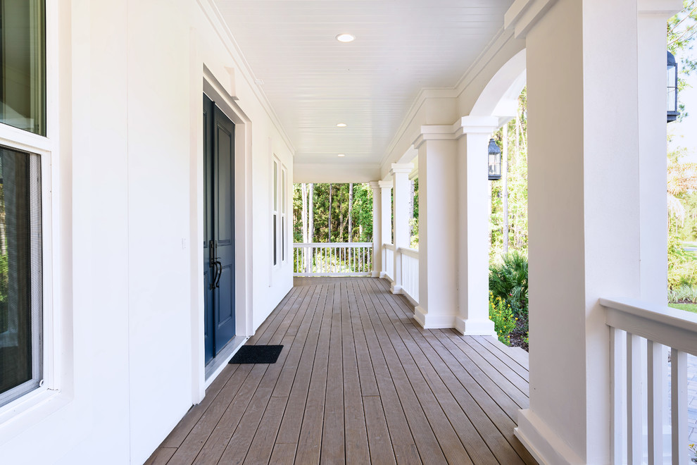 Aménagement d'un porche d'entrée de maison avant bord de mer de taille moyenne avec une terrasse en bois et une extension de toiture.