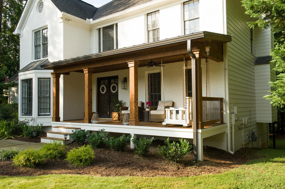 Inspiration pour un porche d'entrée de maison avant traditionnel avec une terrasse en bois et une extension de toiture.
