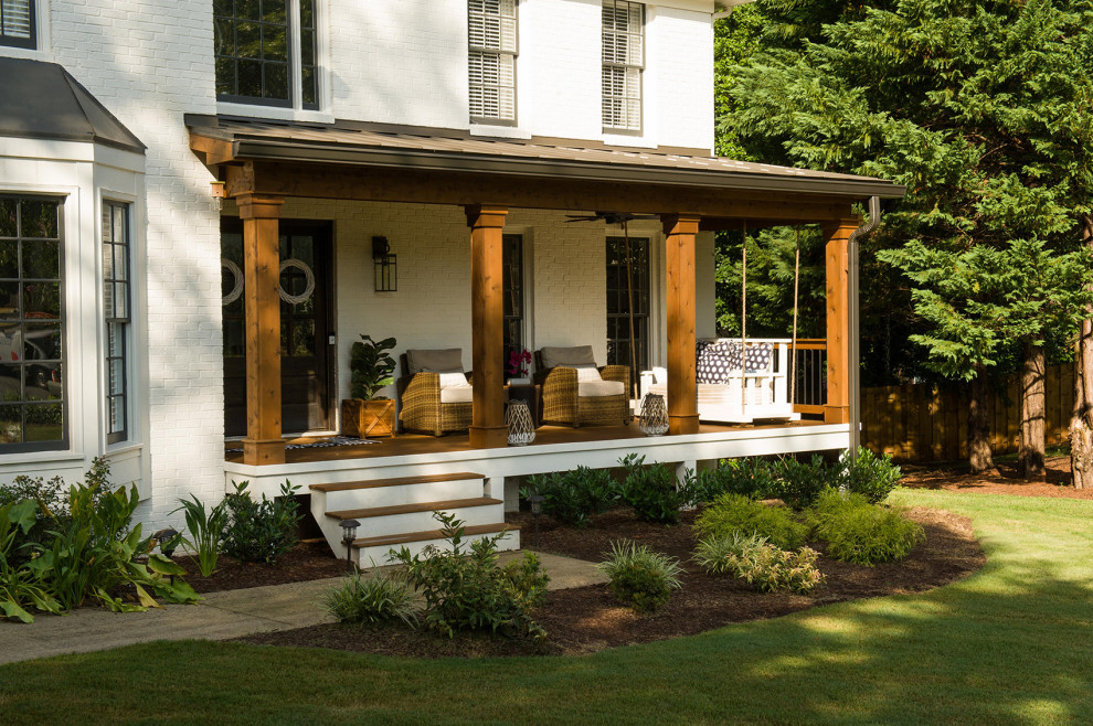 This is an example of a traditional front veranda in Atlanta with with columns, decking and a roof extension.