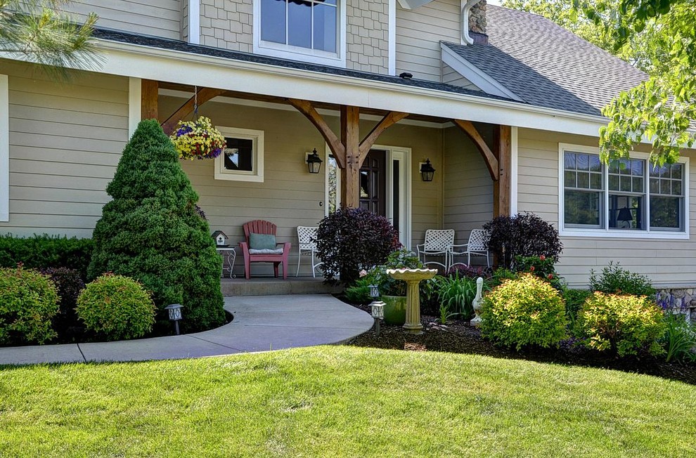 Cette photo montre un porche d'entrée de maison avant montagne de taille moyenne avec une dalle de béton et une extension de toiture.