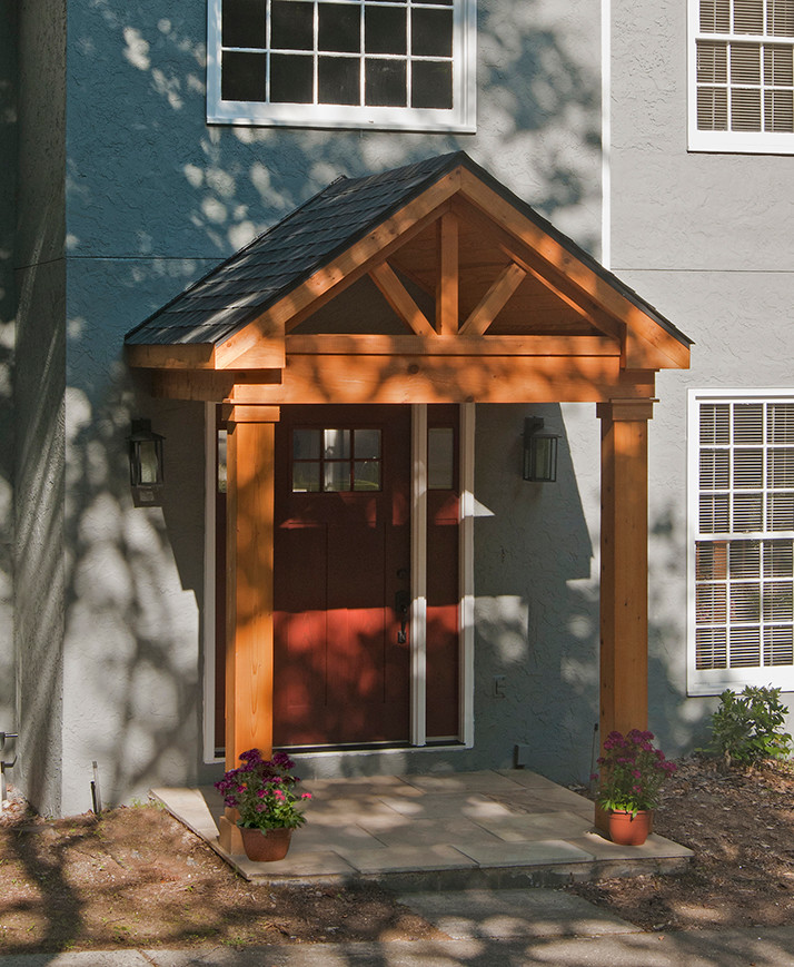 Idée de décoration pour un porche d'entrée de maison avant tradition avec une extension de toiture.
