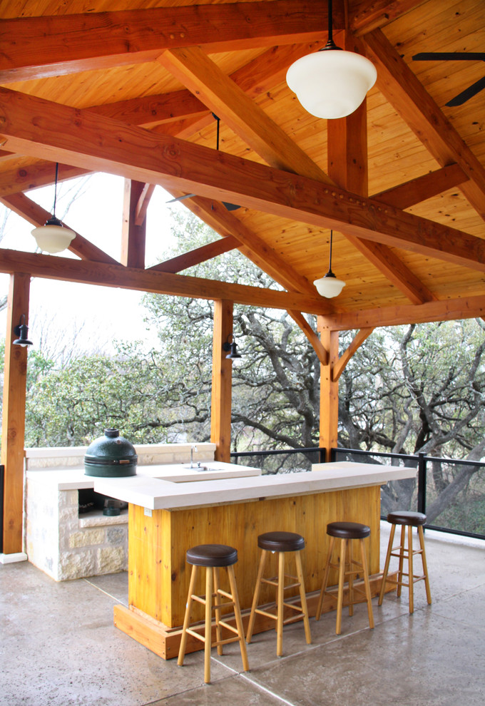 This is an example of a traditional veranda in Austin with concrete slabs, a roof extension and a bar area.