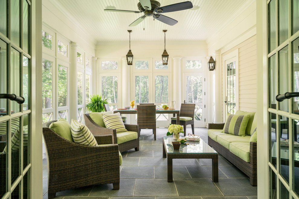 This is an example of a large traditional veranda in Boston with a roof extension and feature lighting.