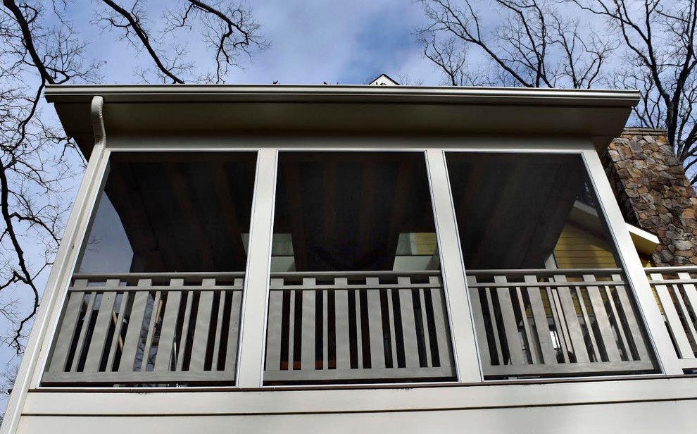 This is an example of a medium sized classic back screened veranda in DC Metro with decking and a roof extension.
