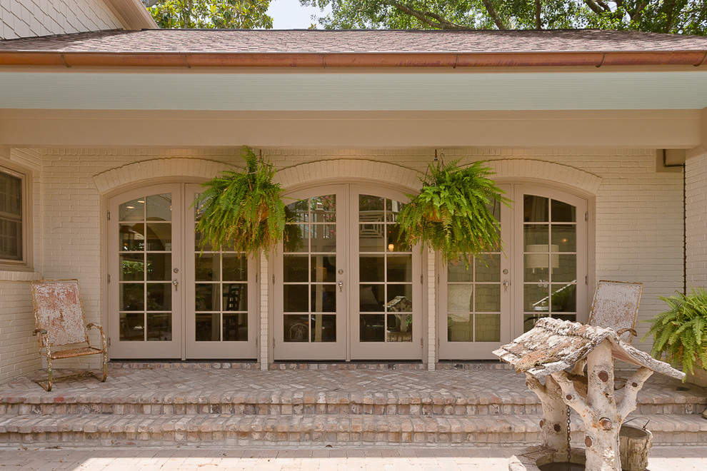Mittelgroße, Überdachte Klassische Veranda hinter dem Haus mit Wasserspiel und Pflastersteinen in Houston