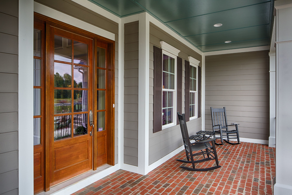 Elegant brick porch photo in Cleveland with a roof extension