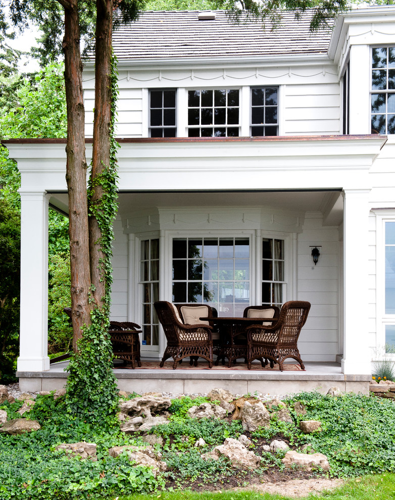 Cette photo montre un porche d'entrée de maison chic avec une extension de toiture.