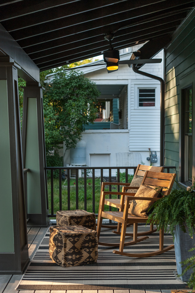 Exemple d'un petit porche d'entrée de maison avant chic avec une extension de toiture et une terrasse en bois.