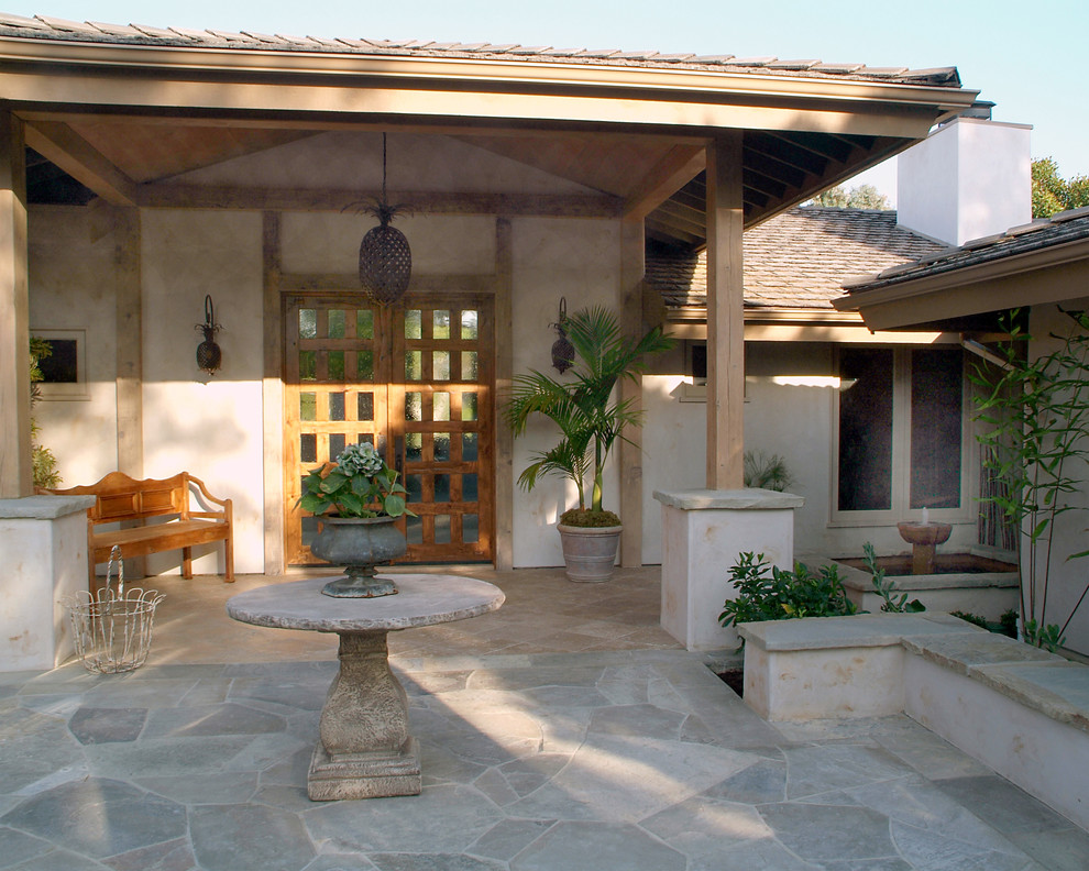 Idee per un portico tradizionale con pavimentazioni in pietra naturale e un tetto a sbalzo