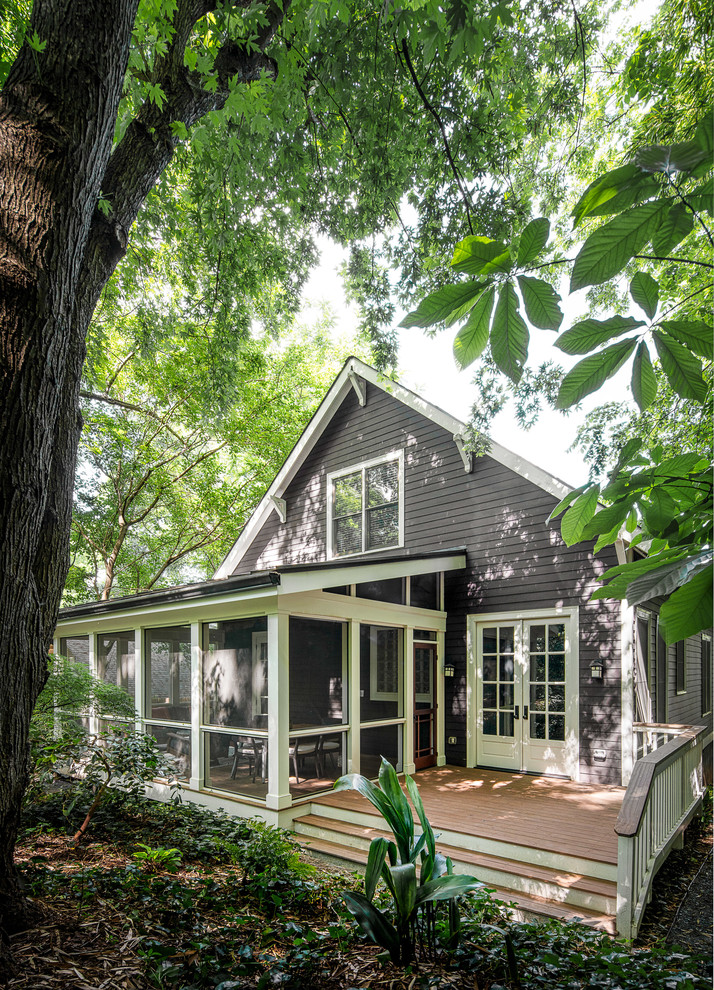 Cette photo montre un grand porche d'entrée de maison arrière chic avec une moustiquaire, une terrasse en bois et une extension de toiture.