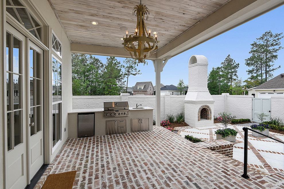 Idées déco pour un grand porche d'entrée de maison arrière classique avec une cuisine d'été, des pavés en brique et une extension de toiture.
