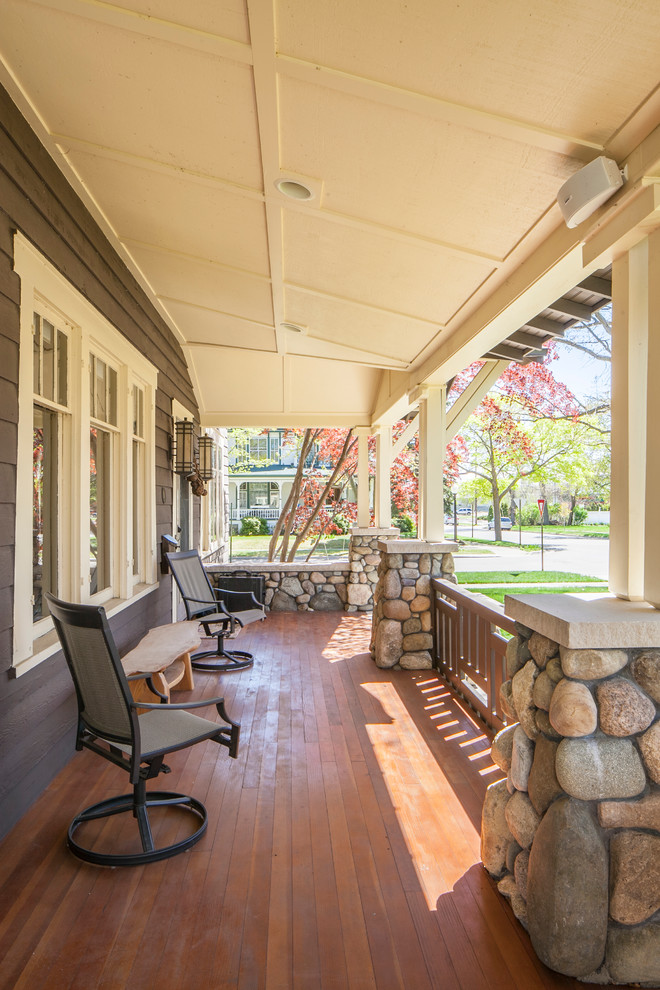Cette photo montre un porche d'entrée de maison arrière craftsman de taille moyenne avec une terrasse en bois et une extension de toiture.