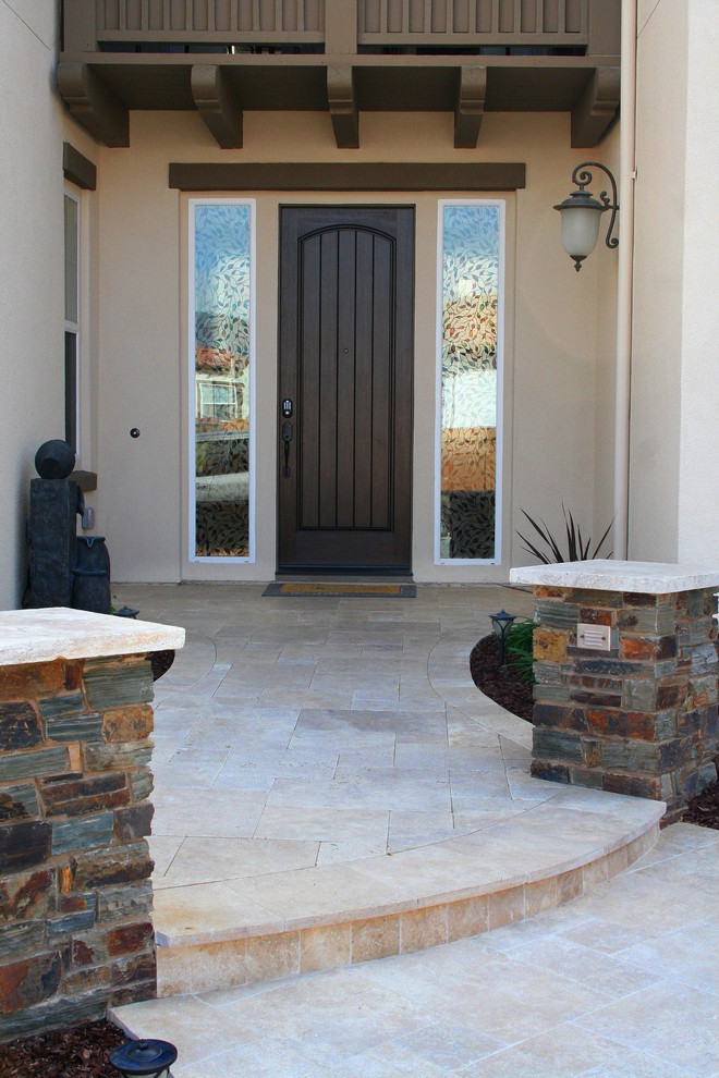 Cette photo montre un porche d'entrée de maison avant chic avec des pavés en pierre naturelle.