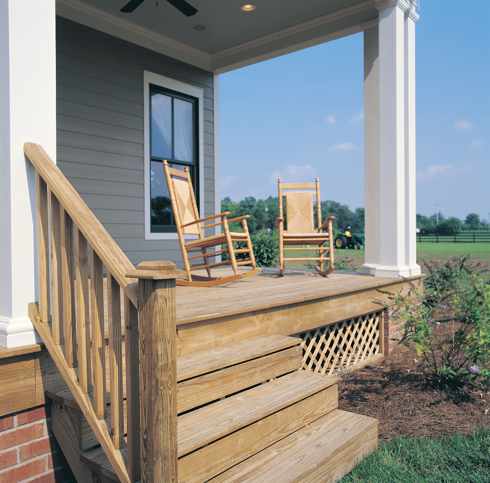 This is an example of a mid-sized farmhouse front porch design in Other with decking and a roof extension.