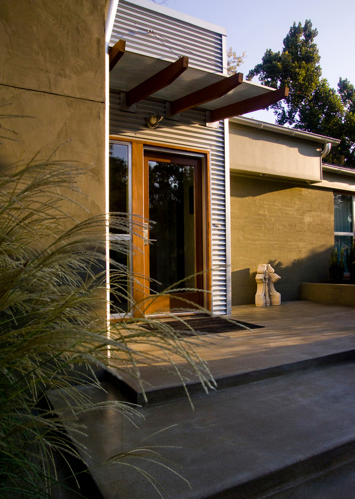 Imagen de terraza contemporánea de tamaño medio en patio delantero con losas de hormigón y toldo