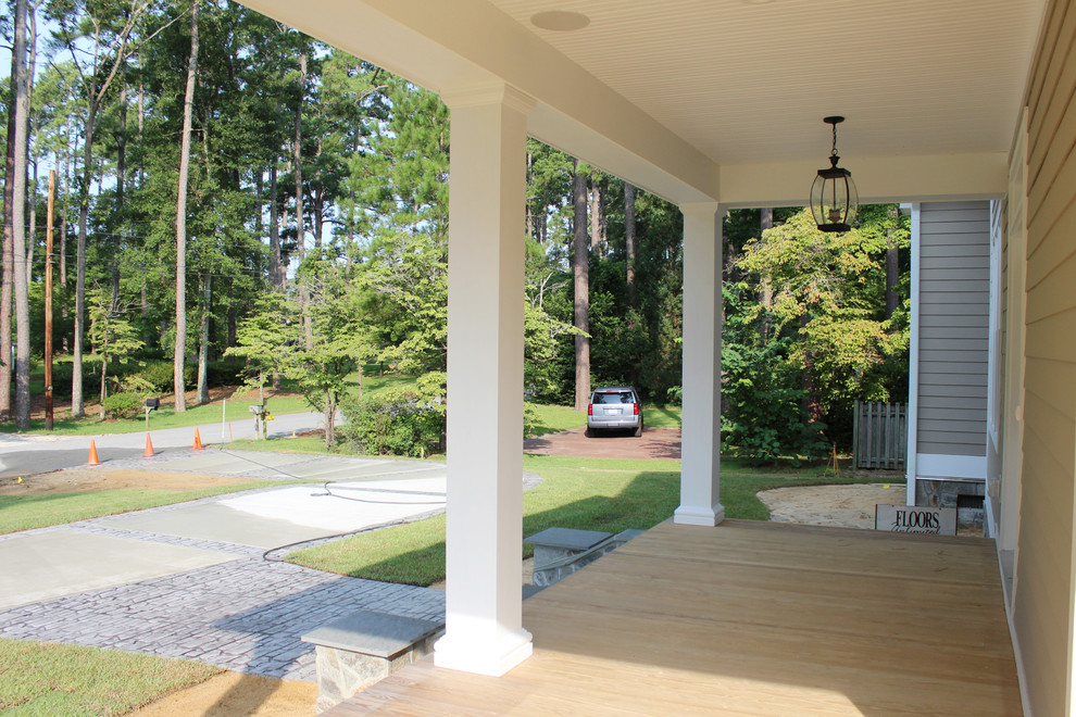 Ejemplo de porche cerrado de estilo americano de tamaño medio en patio delantero y anexo de casas con entablado