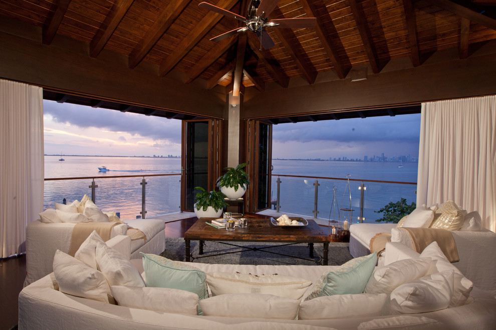 Inspiration for a medium sized world-inspired back screened veranda in Miami with a roof extension and decking.