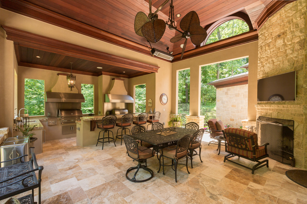 Photo of an expansive classic back veranda in DC Metro with an outdoor kitchen, natural stone paving and a roof extension.