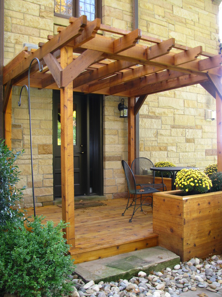 Inspiration pour un grand porche avec des plantes en pot latéral vintage avec une terrasse en bois et une pergola.