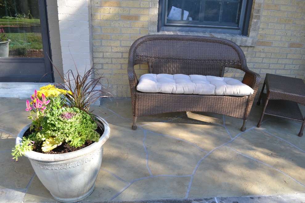 Photo of a medium sized mediterranean front veranda in St Louis with stamped concrete and a roof extension.