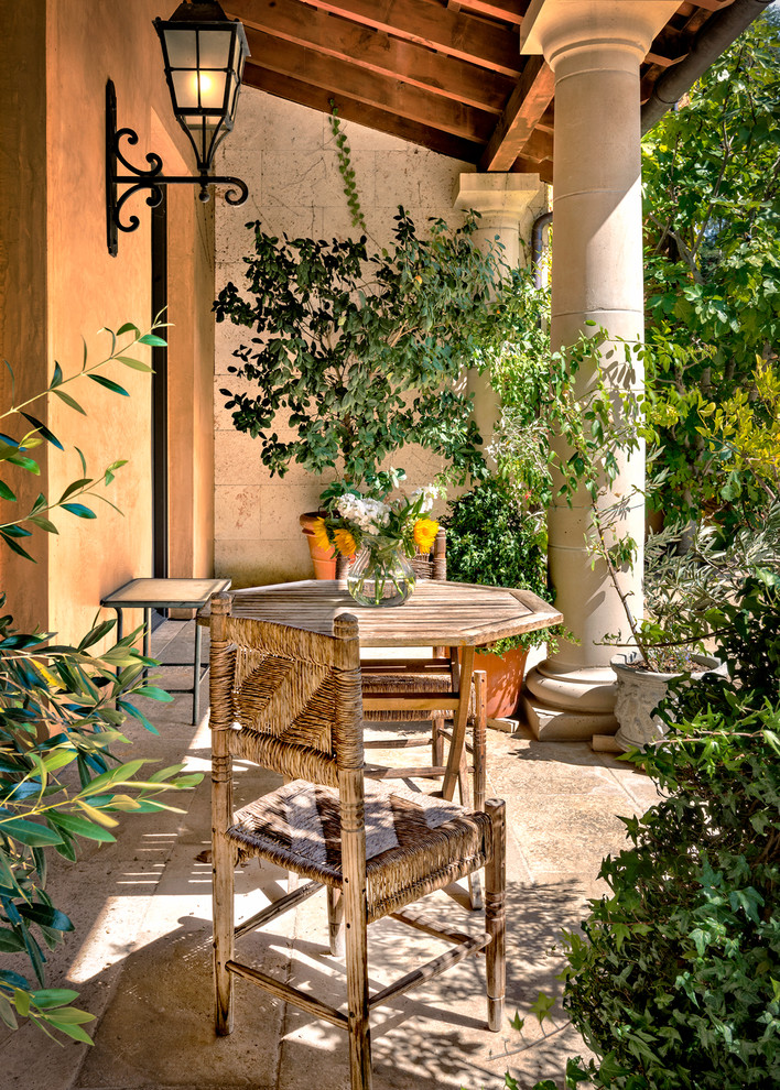This is an example of a mediterranean front patio in San Francisco with natural stone paving and an awning.