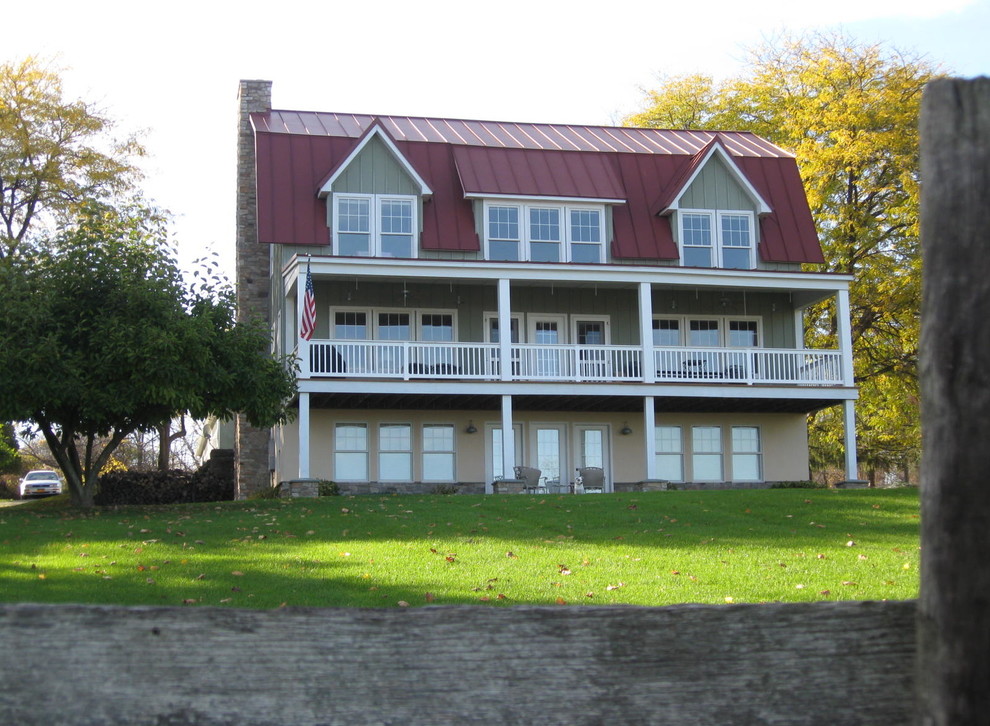Exempel på en stor lantlig veranda framför huset, med trädäck och takförlängning