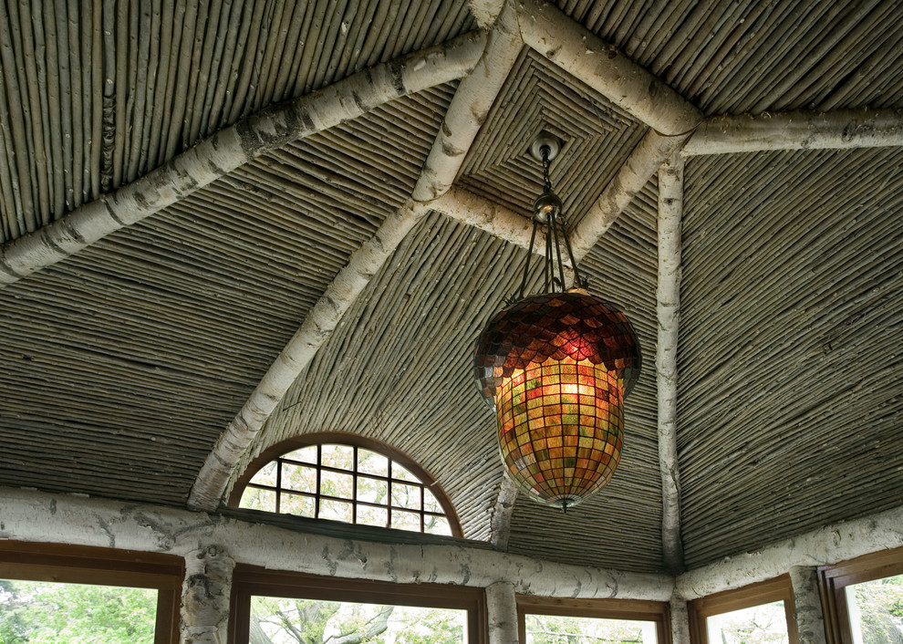 Huge eclectic stone screened-in back porch photo in Boston with a pergola