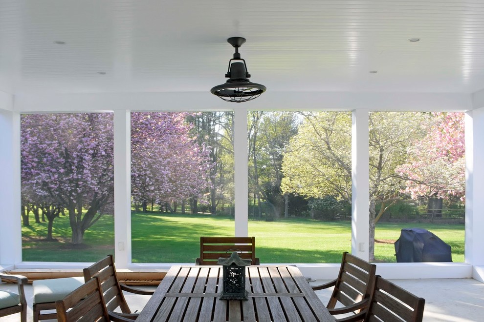 На фото: большая веранда на заднем дворе в стиле неоклассика (современная классика) с крыльцом с защитной сеткой, покрытием из бетонных плит и навесом