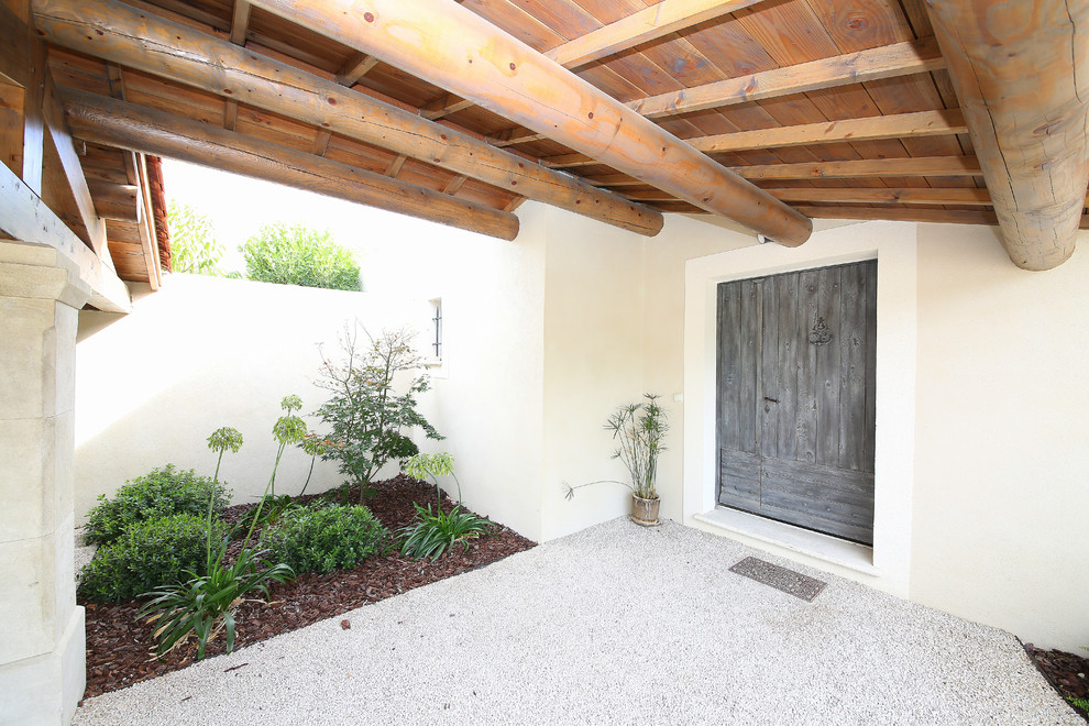 Cette photo montre un porche d'entrée de maison arrière méditerranéen avec un auvent.