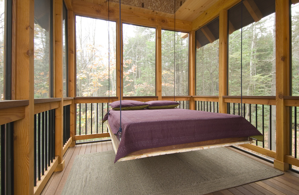 Aménagement d'un porche d'entrée de maison montagne avec une terrasse en bois, une extension de toiture et une moustiquaire.