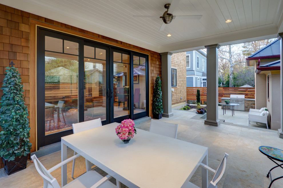 Foto på en funkis veranda på baksidan av huset, med naturstensplattor och takförlängning