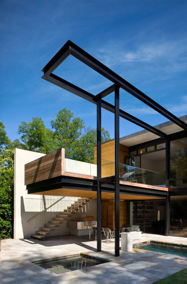 Foto di un portico minimalista di medie dimensioni e dietro casa con pavimentazioni in pietra naturale e un tetto a sbalzo