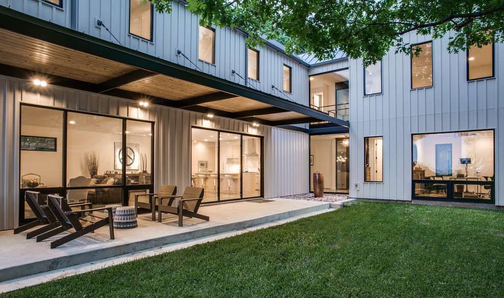 Idées déco pour un grand porche d'entrée de maison arrière moderne avec une dalle de béton.