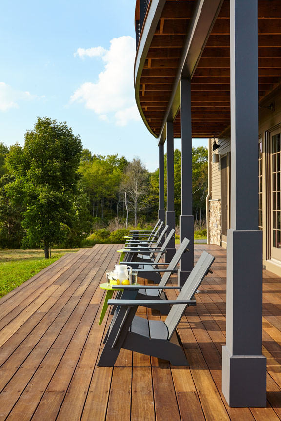 Cette photo montre un grand porche d'entrée de maison arrière nature avec une terrasse en bois et une extension de toiture.