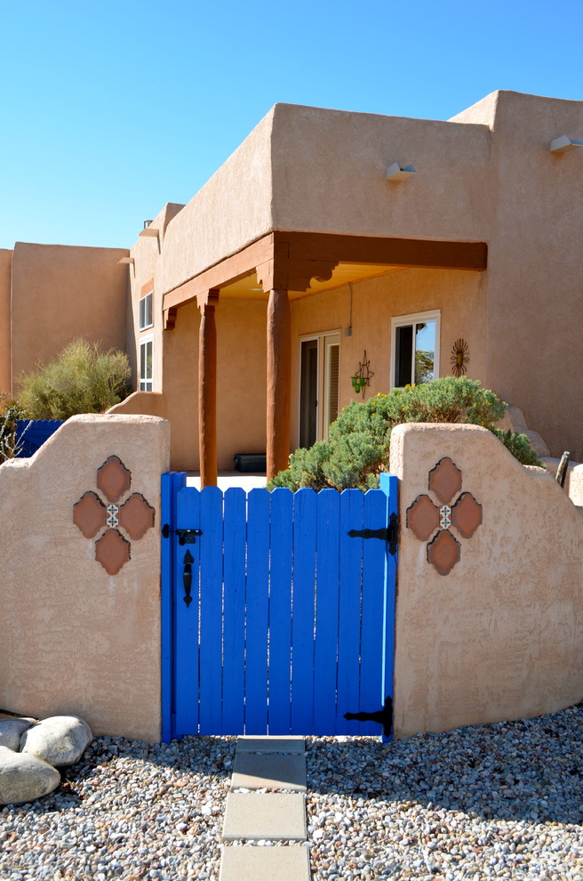 Idée de décoration pour un grand porche d'entrée de maison arrière sud-ouest américain avec une dalle de béton et une extension de toiture.