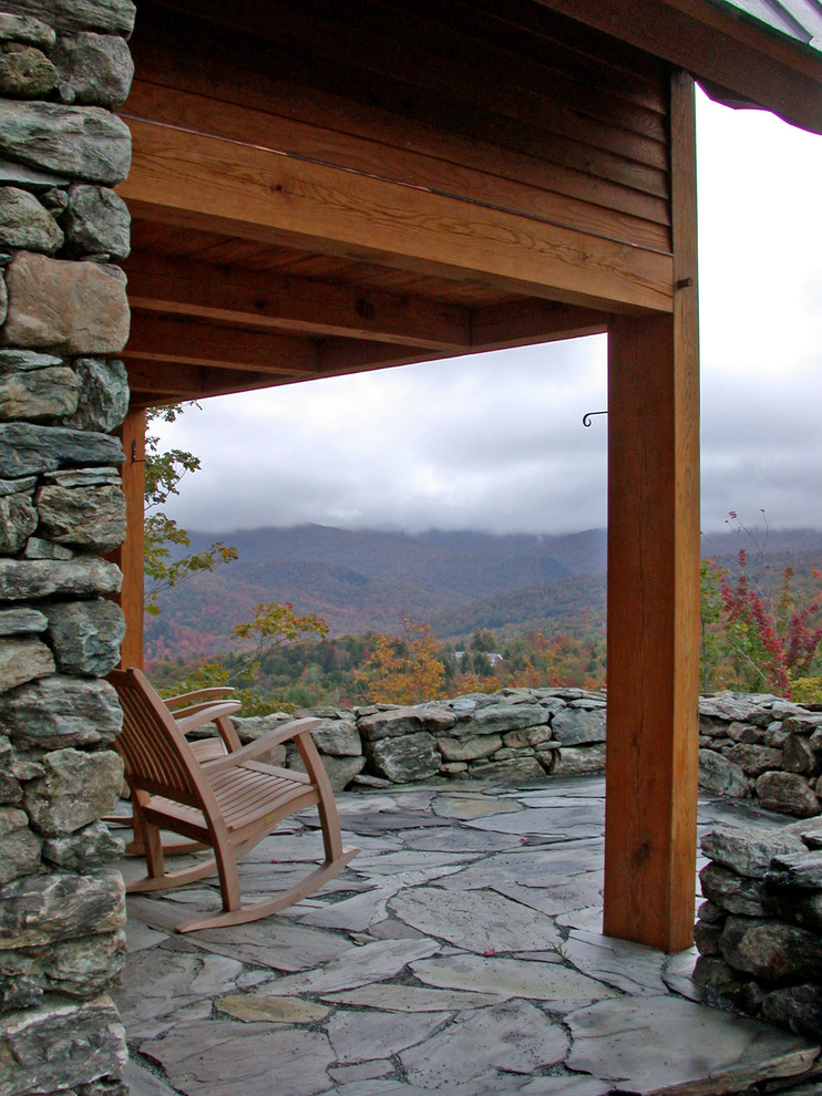 Aménagement d'un porche d'entrée de maison montagne avec des pavés en pierre naturelle et une extension de toiture.
