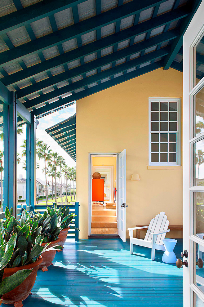 This is an example of a tropical porch design in Miami with decking and a roof extension.