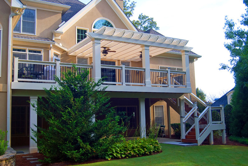 Cette photo montre un porche d'entrée de maison arrière chic avec une terrasse en bois et une pergola.