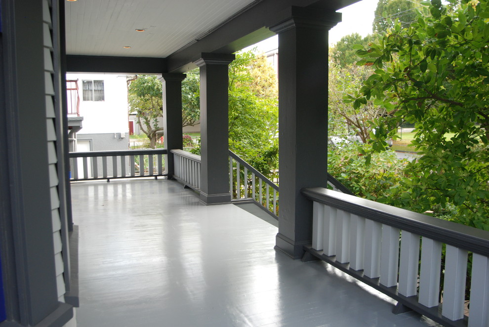 This is an example of a medium sized retro front veranda in Vancouver with a roof extension and decking.