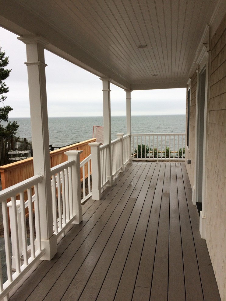 This is an example of a mid-sized coastal front porch design in Boston with a roof extension.