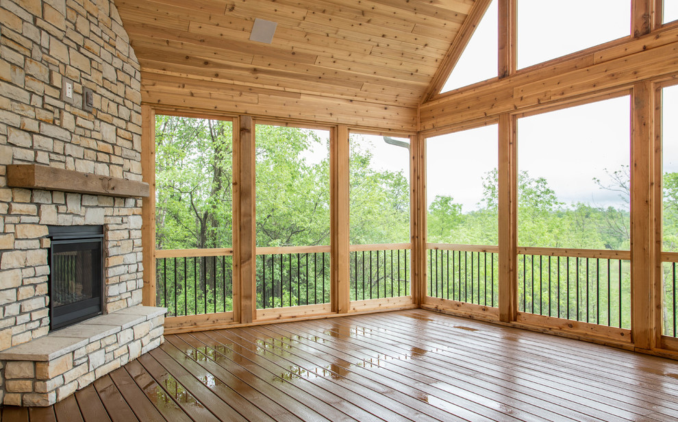 Cette photo montre un grand porche d'entrée de maison latéral nature avec une moustiquaire, une terrasse en bois et une extension de toiture.