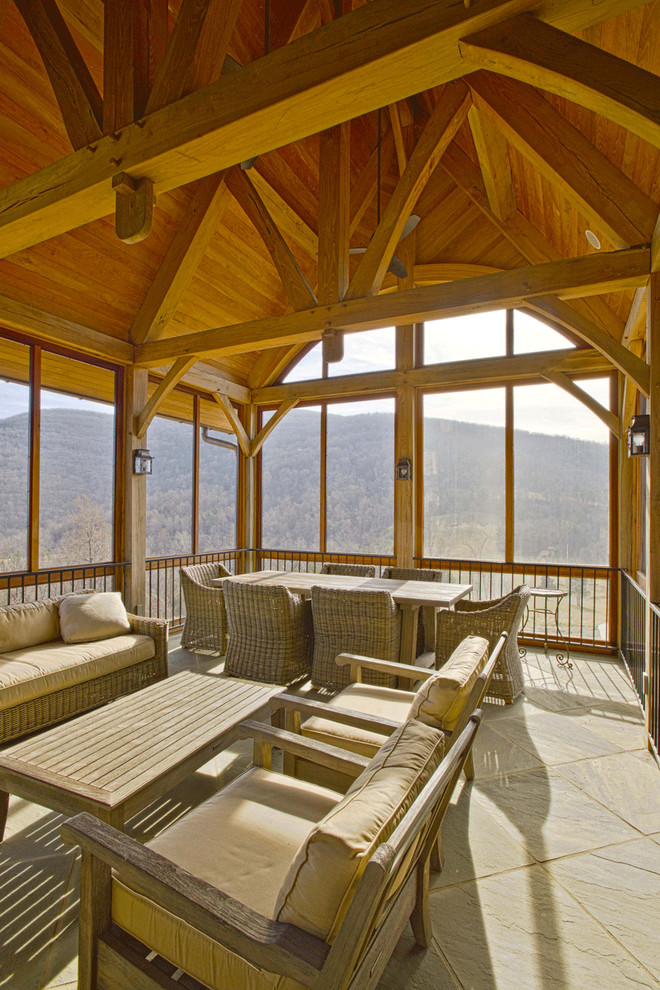 Large mountain style concrete paver screened-in back porch idea in Other with a roof extension