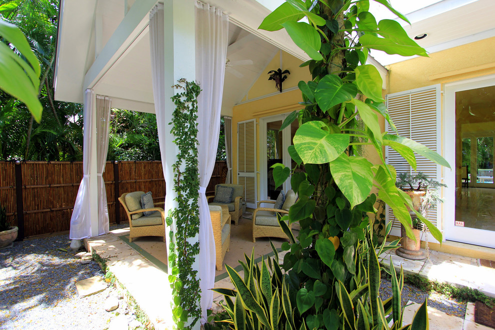 Idéer för en mellanstor exotisk veranda framför huset, med en vertikal trädgård, naturstensplattor och takförlängning