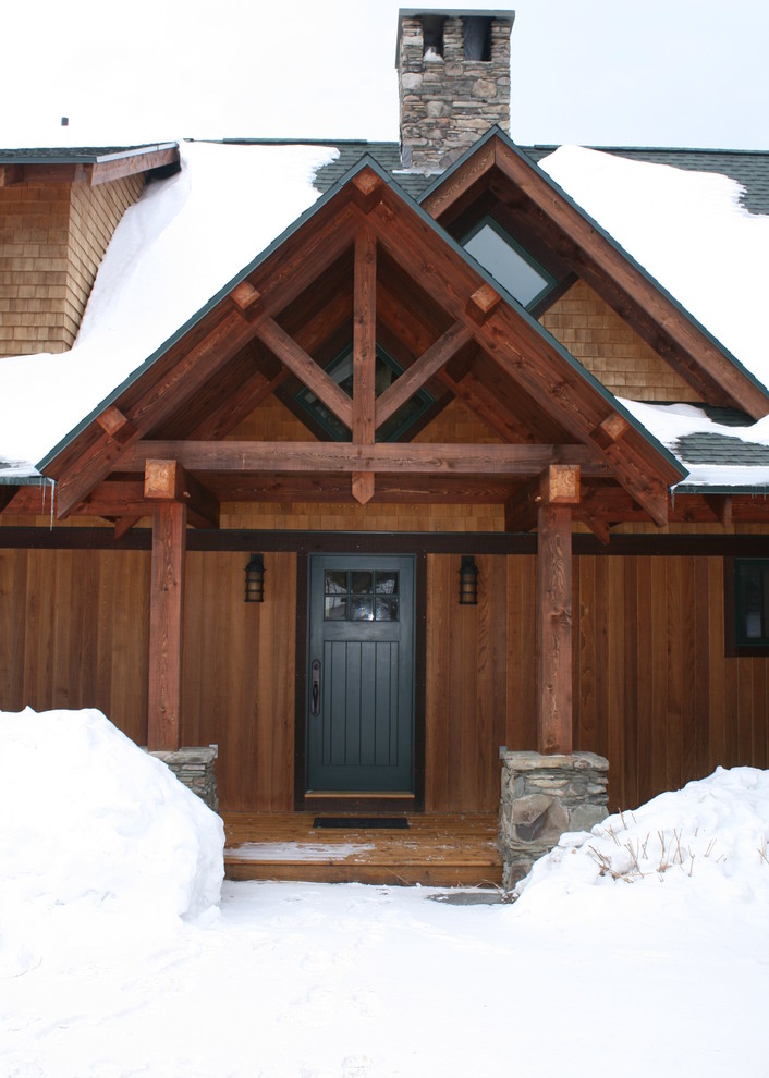 Idée de décoration pour un porche d'entrée de maison avant chalet de taille moyenne avec une terrasse en bois et une extension de toiture.